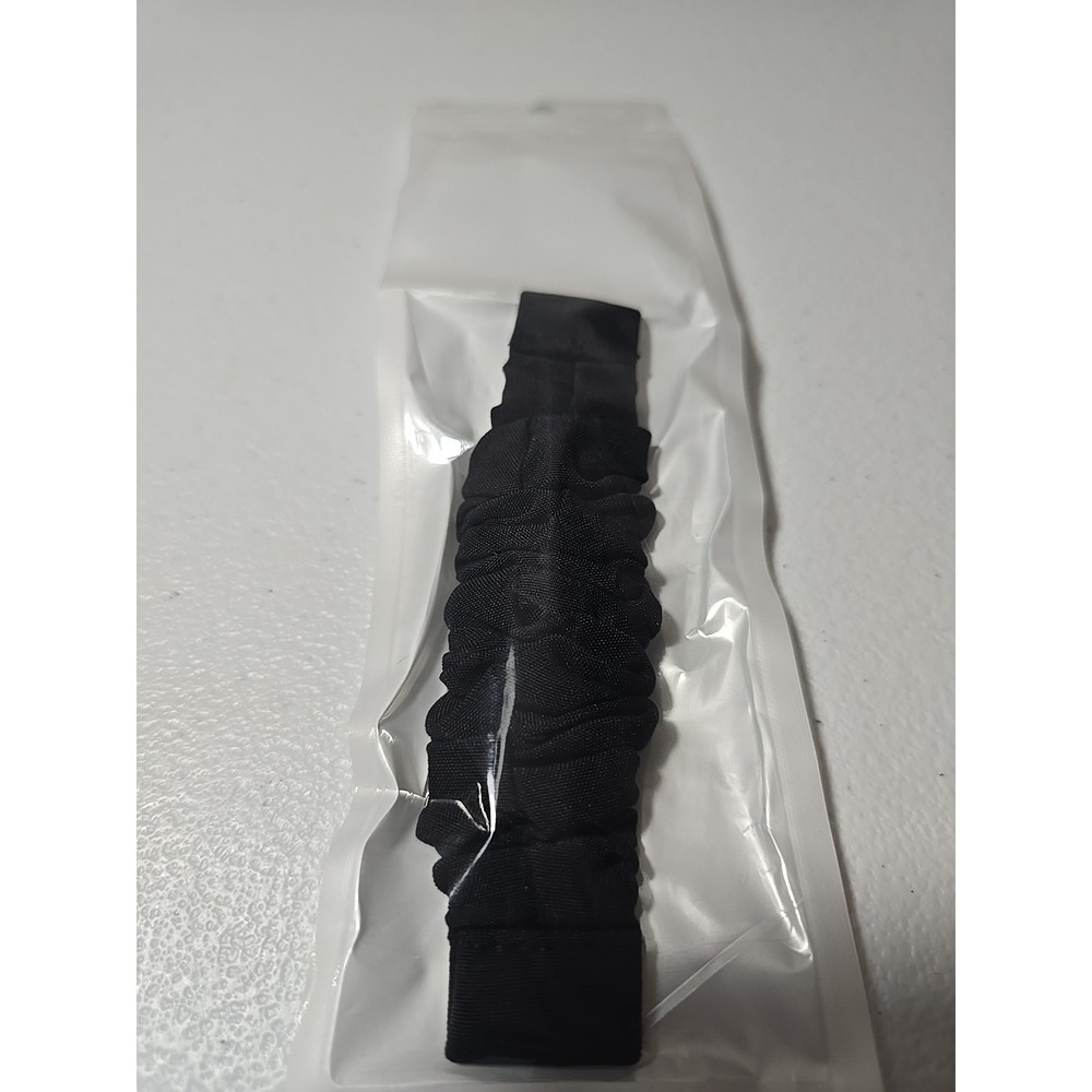 Scrunchie-style watch band for a fitness tracker, made of a black, ruched fabric